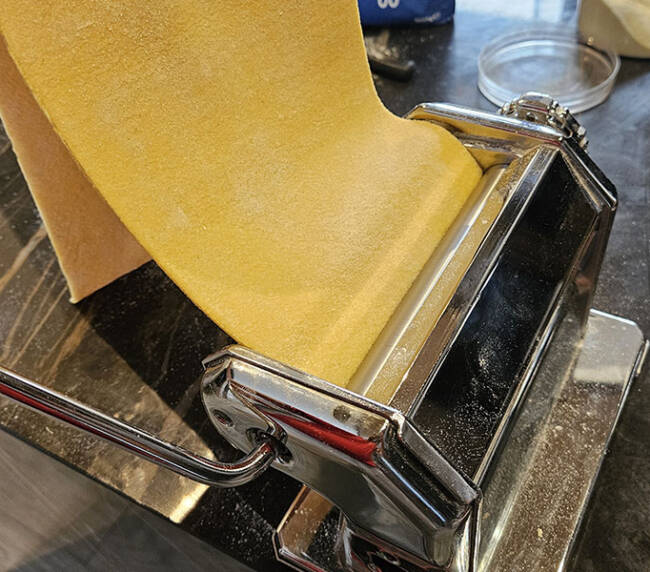 Pasta dough being rolled through a sheeter, cooking class, Menaggio, Lake Como